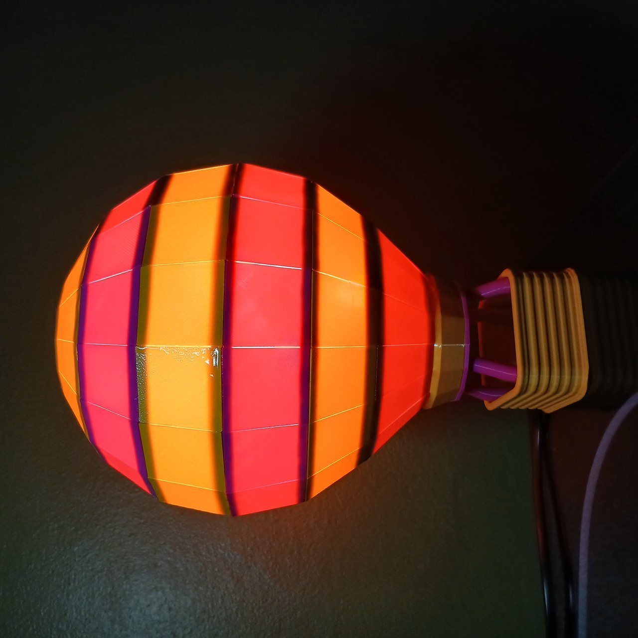 Modelo Solara da Baluminaria, aceso em laranja, coral e roxo